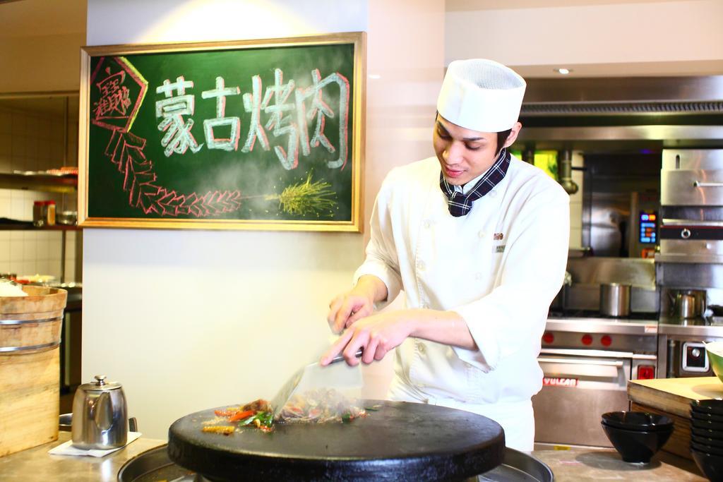 فندق شاتو دي شاين هوالين مدينة هوالين المظهر الخارجي الصورة A Chinese chef cooking with a wok